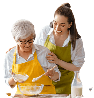 Elderly Woman Baking With Female Staff Member in Independent Living Community