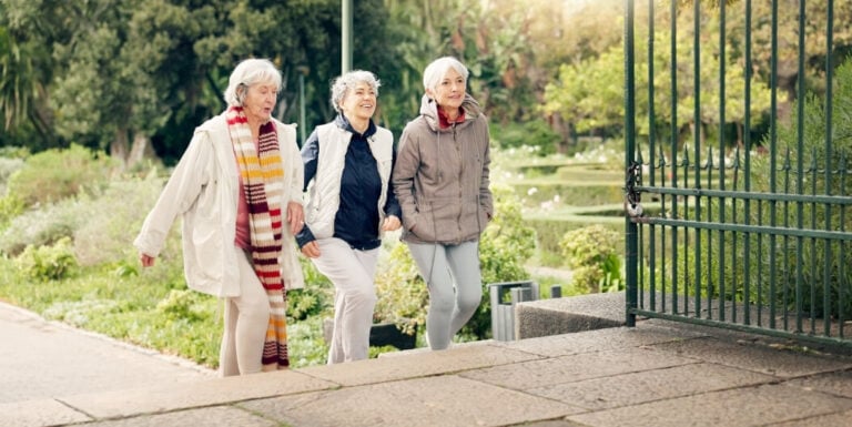 Elderly Women Walking Together through a Garden Park near Independent Living Facility