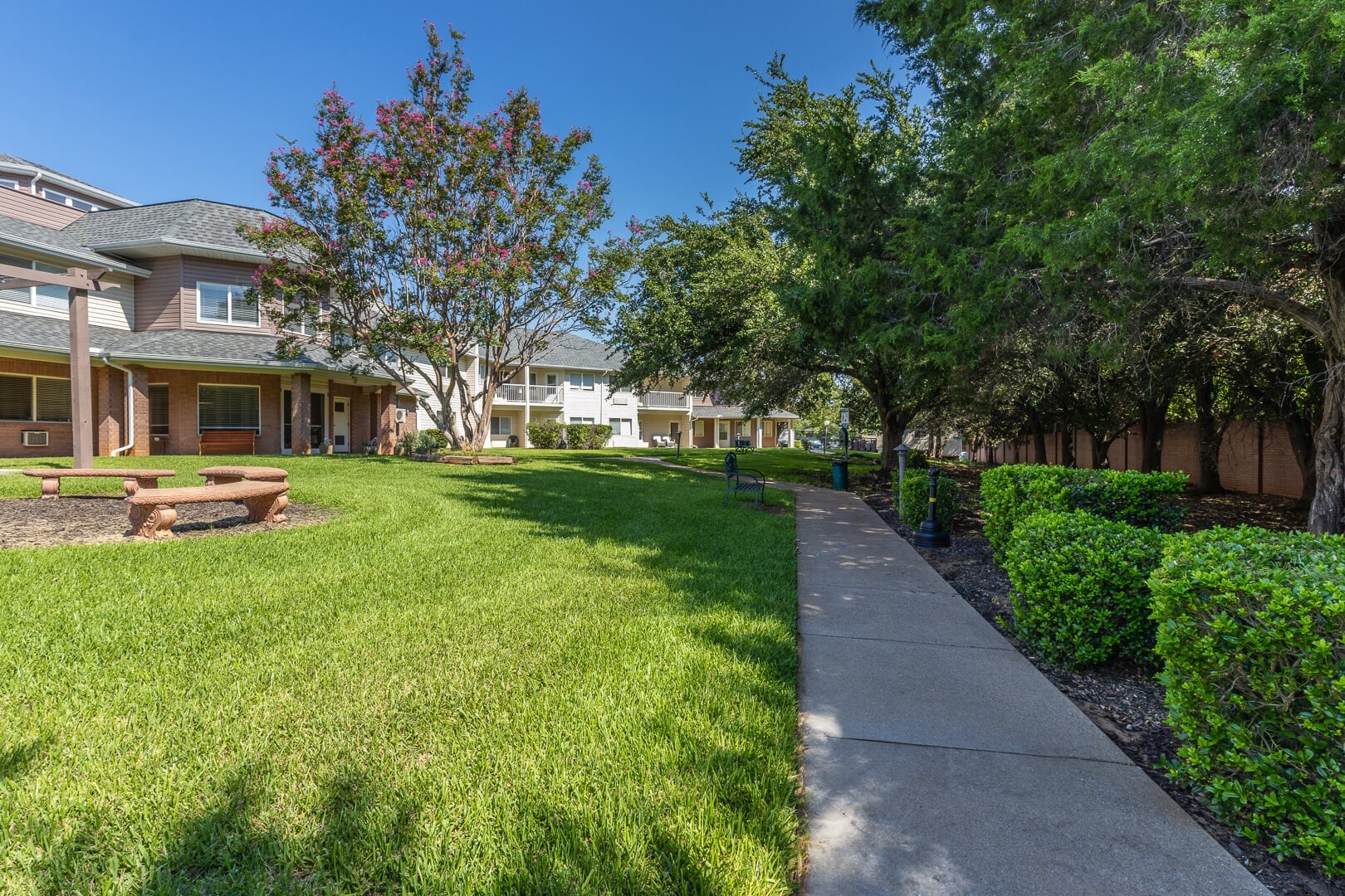 Manicured Garden Walkway beside the Building Exterior in Our Independent Living Community