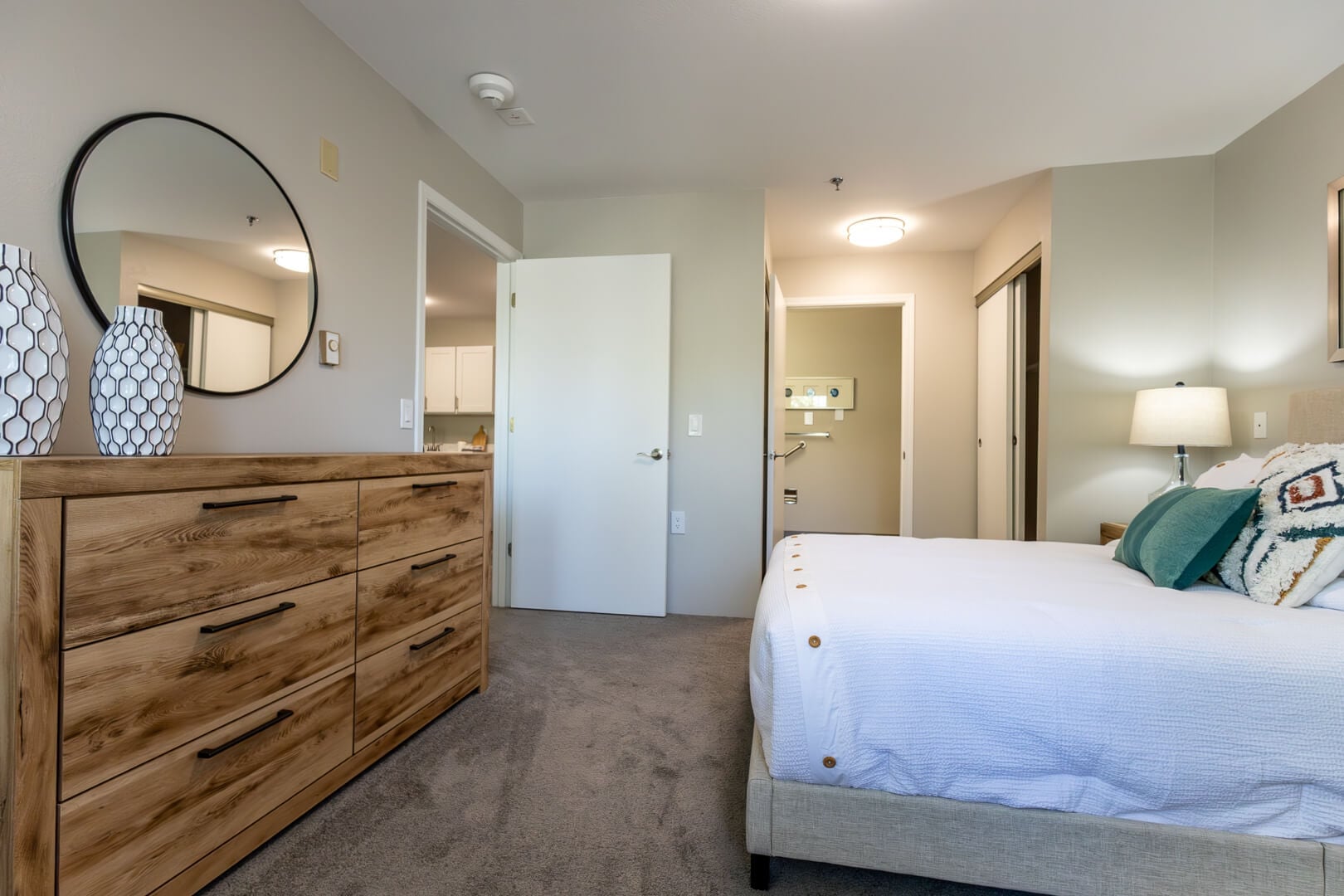 Comfortable Bedroom with Dresser, Mirror, and Soft Lighting in Our Independent Living Facility