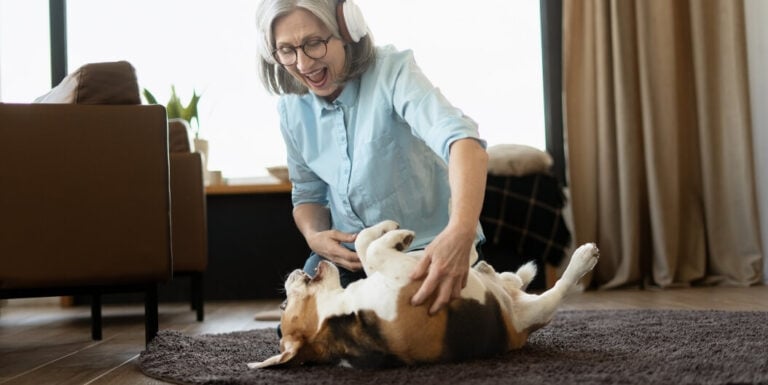Elderly Woman Playing Joyfully with Dog at Independent Living Facility